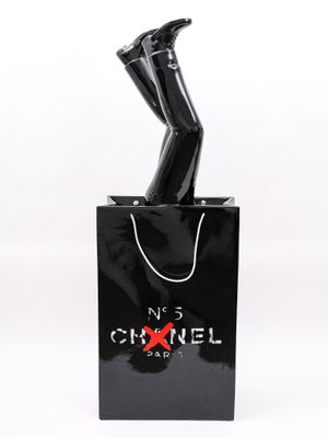 un sac Chanel noir d'où sortent les jambes d'une femme