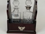 two glass decanters in a wooden case on a white background