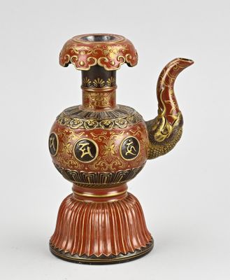 une image représentant un vase rouge et doré orné d'un serpent
