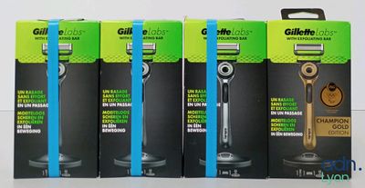 Quatre boîtes de rasoirs Gillette sont alignées sur une table