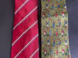 two ties with different designs on them on a table