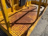 a close up of a yellow lift with a metal grate