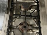 a dirty stove top with a metal burner in it