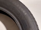 a close up of a tire on the side of a white wall