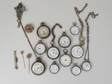 many different types of pocket watches displayed on the wall