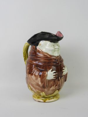 a ceramic figurine of a man wearing a hat and scarf