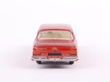 a red toy car that is sitting on a white surface