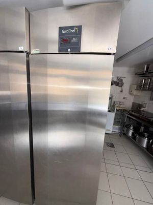 a stainless steel refrigerator in a kitchen with a tile floor