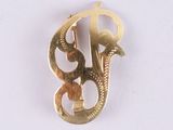 une image représentant une broche en or sur laquelle figure la lettre « b »