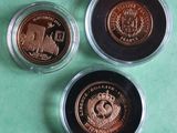 three different coins are in a glass container on a green surface