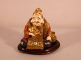 a figurine of a smiling buddha holding a fan