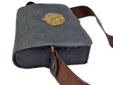 an old book with a leather strap and a gold medallion on it