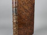 a brown leather book with gold trimming and ornate binding