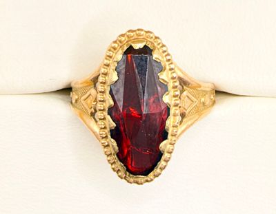 an image of a gold ring with a red stone in it