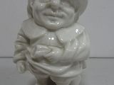 a small white figurine of a man with a hat on
