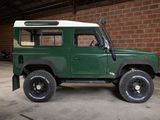 a picture of a green land rover parked in a garage