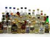 many bottles of alcohol lined up on a white surface