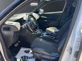 the interior of a car with the door open and the driver ' s seat down