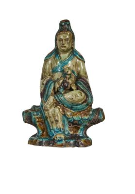 une statue représentant une femme assise sur un rocher