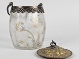 a glass jar with a lid sitting next to a metal container