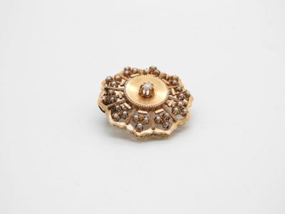 Gros plan sur une broche en or ornée de diamants