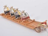 une luge en bois sur laquelle sont posées six bouteilles d'alcool