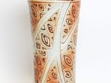 a brown and white vase sitting on a white surface
