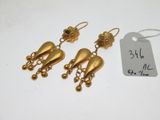 une paire de boucles d'oreilles dorées ornées de clochettes pendantes