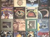 many different album covers on the wall of a room