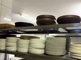 beaucoup d'assiettes et de casseroles sur les étagères de la cuisine