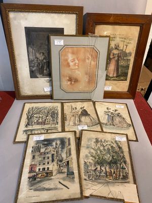 several framed and unframed pictures of people and buildings on a table