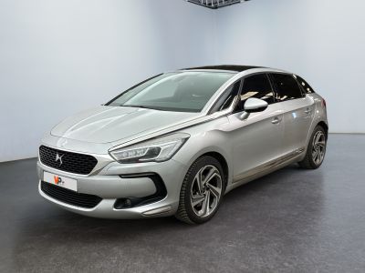 Une voiture argentée est garée dans une grande pièce.
