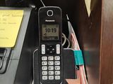 a cell phone sitting on top of a desk next to a telephone