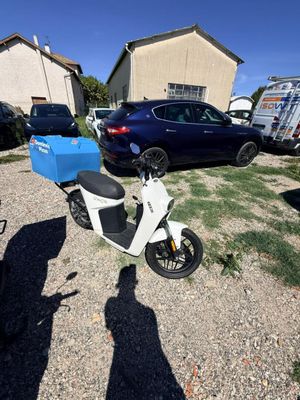 un scooter avec une boîte bleue à l'arrière