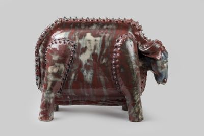 une statue d'éléphant rouge et blanche sur fond gris
