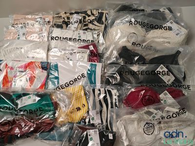 de nombreux types de vêtements différents, rangés dans des sacs posés sur la table