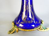 a blue vase with a gold decoration on it