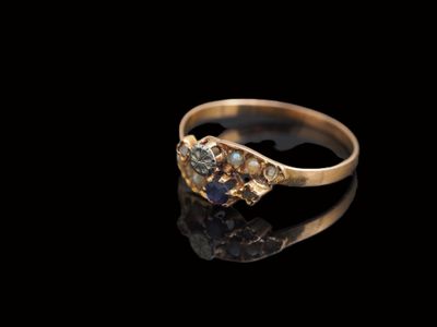 un gros plan d'une bague en or sertie de deux diamants sur un fond noir