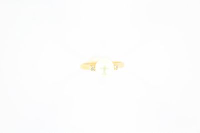 un gros plan d'une bague en or sertie de deux pierres blanches