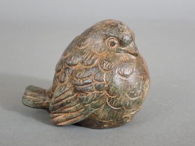 a small statue of a bird sitting on a table