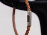 leather bracelet with a silver clasp on a black stand