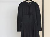 a black dress hanging on a clothes rack in a room