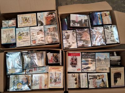 un grand nombre de dvd dans une boîte posée sur le sol