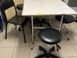 a white table with black chairs and a black stool