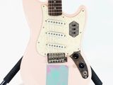 an electric guitar sitting on top of a stand on a white surface