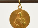 une image représentant une médaille d'or sur laquelle figure une femme tenant un enfant dans ses bras