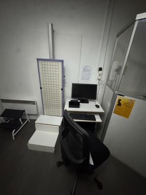 a desk with a computer and a chair in a room