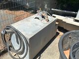 une petite machine posée par terre près d'une clôture