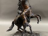 bronze statue of a man on a horse with a bow