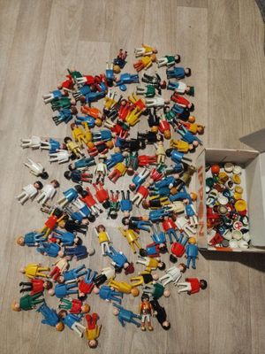 une boîte remplie de petits personnages de jouets posée par terre